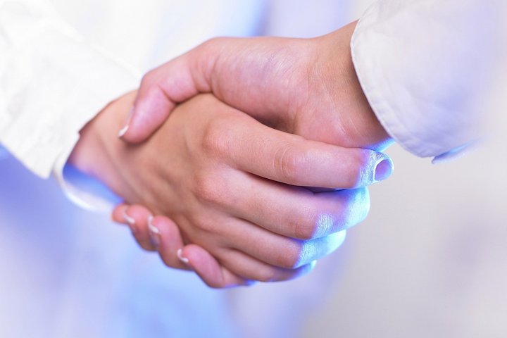 Besisveikinančios rankos šviesoje